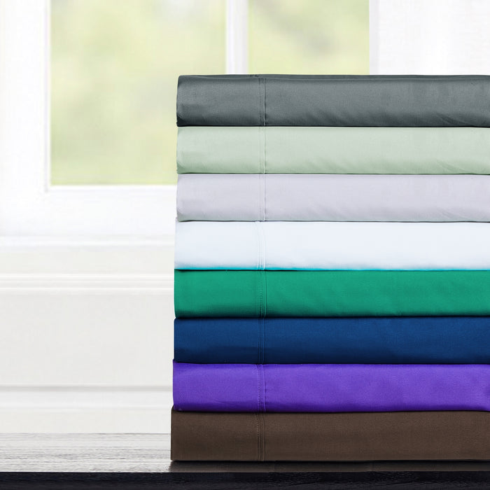 Stack of folded fabric sheets in various colors on a white background