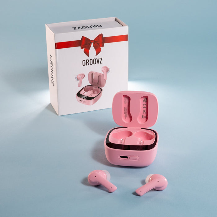 Pink wireless earbuds with open charging case and 'GROOVZ' branded box on a light blue background