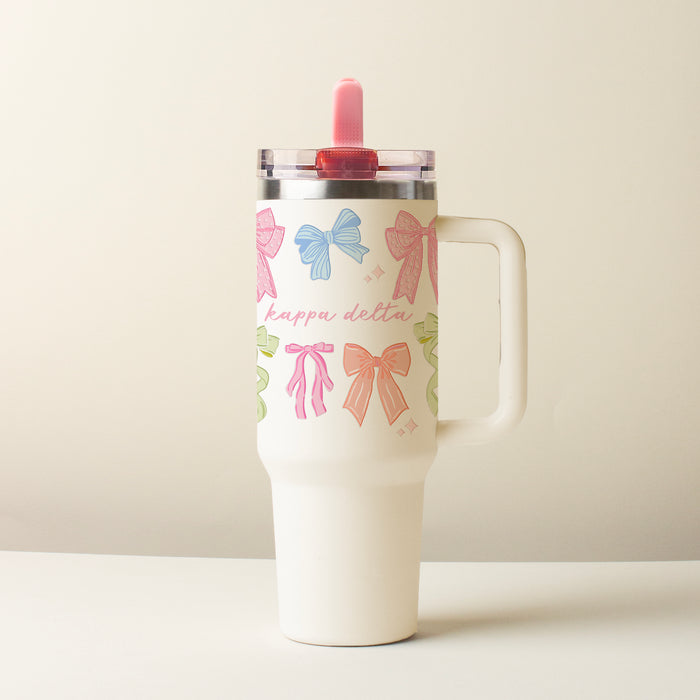 The Darling Effect’s Kappa Delta 40 oz Lifestyle Flip Straw Tumbler Bow Affair features colorful bows, “kappa delta” in pink script, a clear leak-resistant lid, and a pink straw, shown against a plain light background.