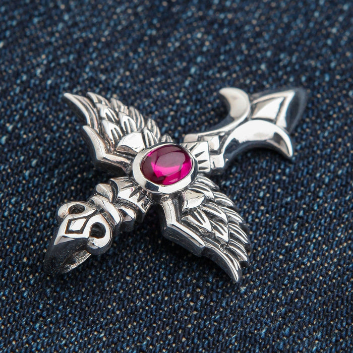 A close-up shot of the red stone winged cross pendant, detailing the smooth cabochon and textured silver.