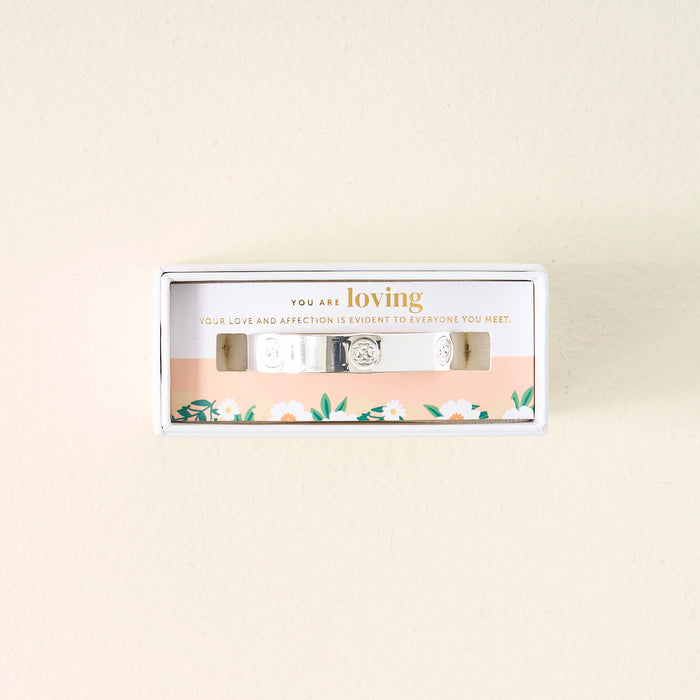 The Darling Effect's You Are Loving Cuff Bracelet, crafted in sterling silver with embossed florals, comes in a white box inscribed with YOU ARE loving and YOUR LOVE AND AFFECTION IS EVIDENT TO EVERYONE YOU MEET—a meaningful gift.