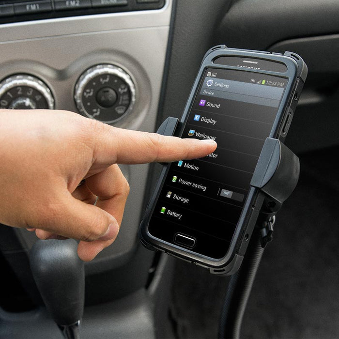 A hand touches a smartphone displaying the settings menu, mounted on the RoadVise® Phone Holder with 15 Gooseneck and Seat Rail Mount in a car, with car controls and gear shift visible in the background.