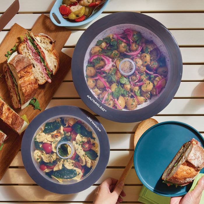Sandwiches and salads rest on the patio table, securely covered with the 2-Piece Silicone Suction Lid Set that provides an airtight seal.