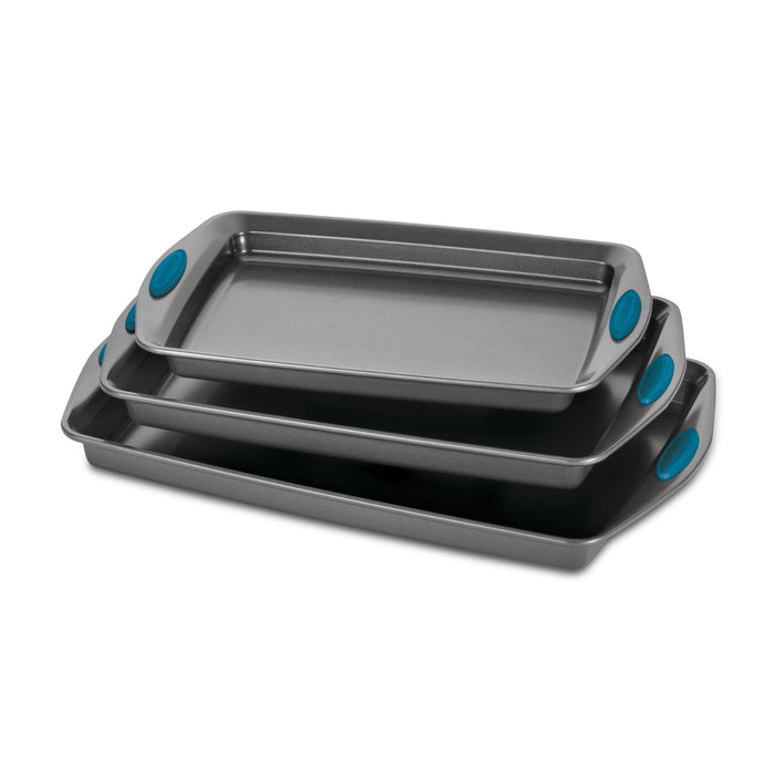 A set of three nonstick sheet pans with blue handle grips, made from durable steel and designed to be oven safe.