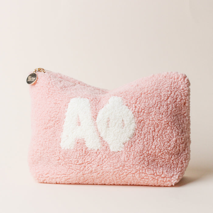 The Darling Effect's Alpha Phi Blush Teddy Letter Pouch features white Alpha Phi letters, a gold zipper and charm—an adorable pink accessory for Alpha Phi members or anyone who loves plush pouches.