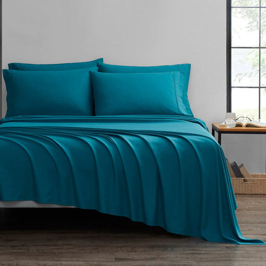 A set of teal-colored bamboo sheets on a bed, with a fitted sheet, flat sheet, and pillowcases displayed in a room setting.
