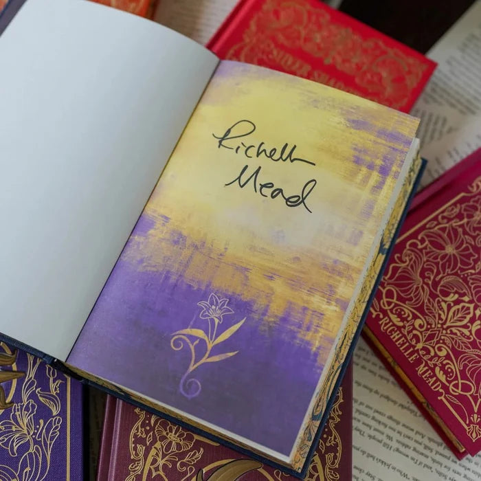 Bloodlines Special Edition Box Set by Richelle Mead – signed page featuring the author's handwritten signature on a purple and gold painted spread with a gold lily illustration