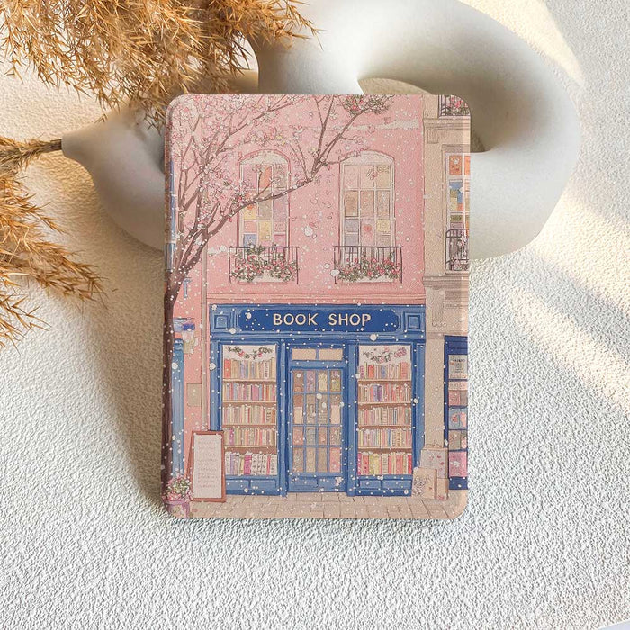 A Kindle case featuring an illustration of a bookshop on a pink background.