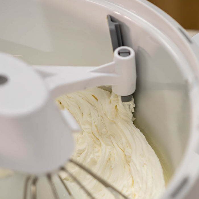 NutriMill bowl scraper scraping icing off of the side of a bowl