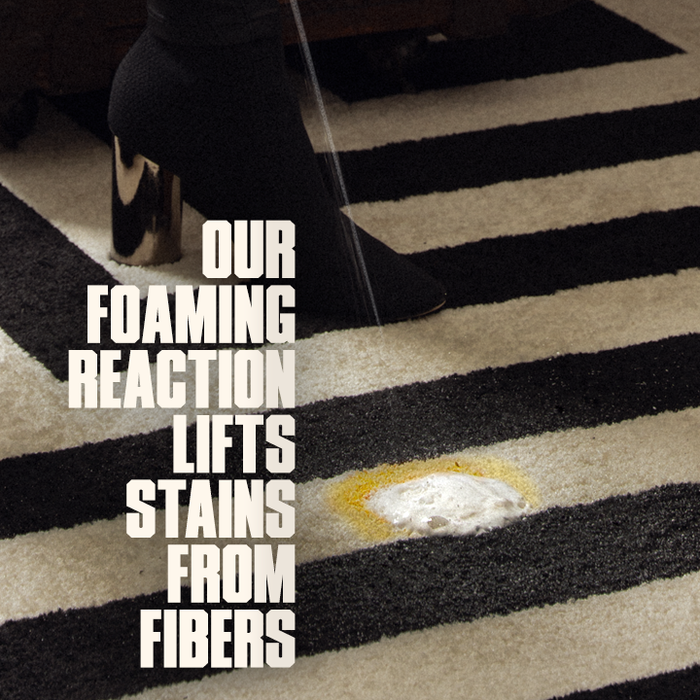Text on a striped carpet with a stain, indicating a cleaning product's effectiveness.