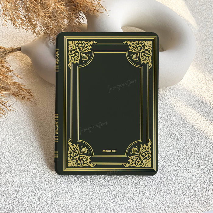 Decorative black book with gold embellishments on a textured white surface.