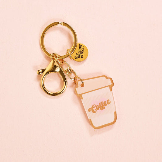 The Coffee Cup Acrylic Keychain by the-darling-effect features gold hardware and durable acrylic, adding a sweet touch to your keychain collection. This charming accessory stands out with its coffee cup shape and cute design.