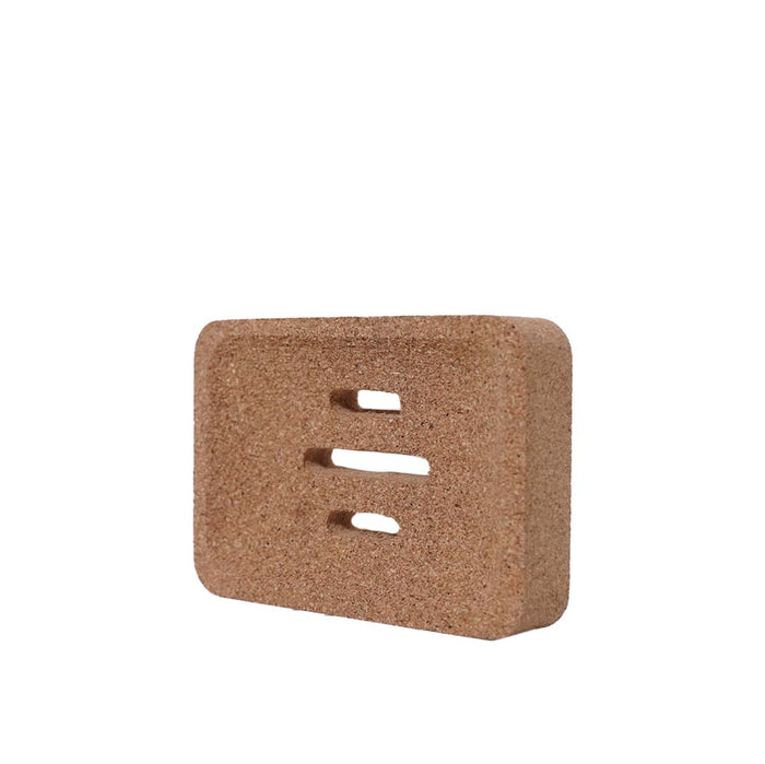 Square cork coaster with three holes on a white background