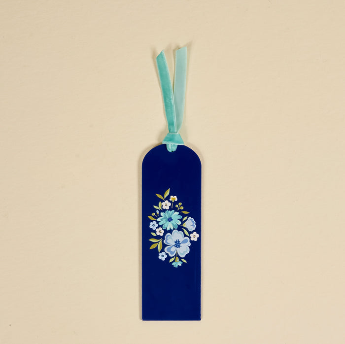 The Dainty Floral Navy Acrylic Bookmark by the-darling-effect features blue and white painted flowers, a rounded top, and a light blue velvet ribbon tassel—an elegant gift for book lovers.