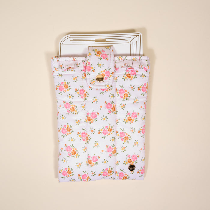 The Endless Daydream Cream Book Cover by the-darling-effect is a white quilted pouch with pink and yellow flowers, gold button clasp, and heart charm—perfect as a cute book sleeve or for holding cards and envelopes.