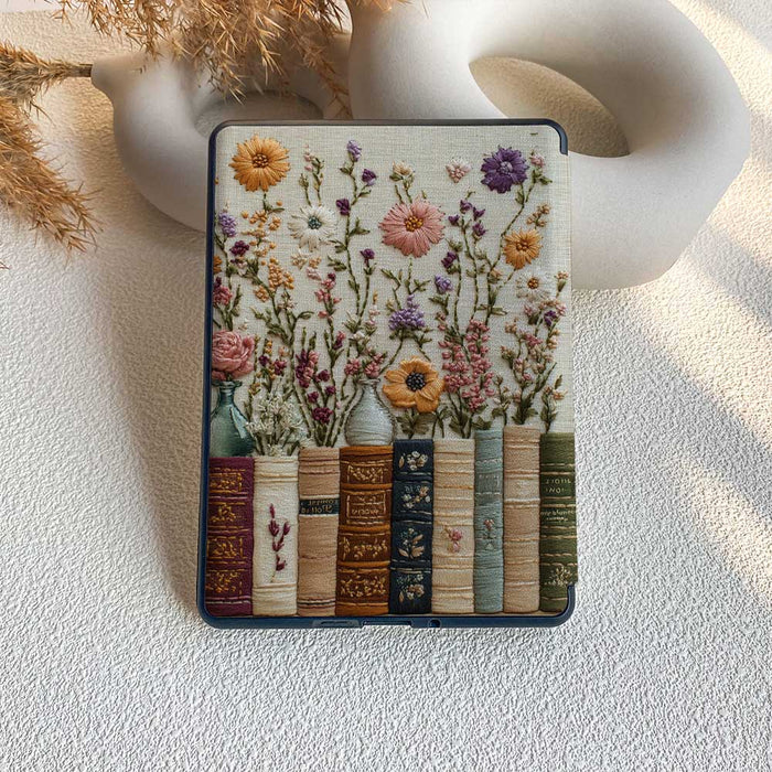 Floral design phone case with books and flowers on a textured surface