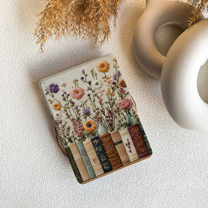 Decorative mouse pad with floral and book design on a textured surface