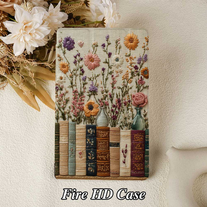 Floral embroidered case with books design on a textured surface, surrounded by flowers.