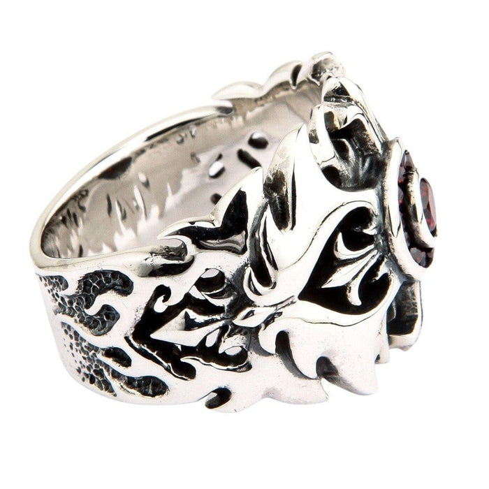 Side view of 925 sterling silver ring featuring flame-like scroll engravings and textured band with red garnet visible at edge