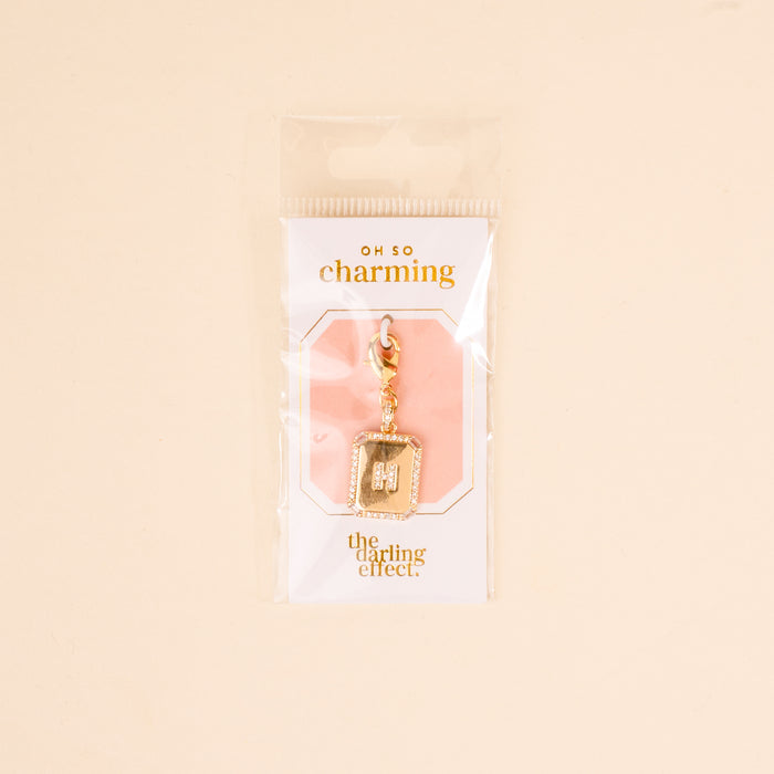 The H Jewelry Charm Initial Letter Gold by the-darling-effect features a gold-plated, rhinestone-encrusted letter H with a lobster clasp, packaged in plastic—ideal for adding personalized sparkle to your style.