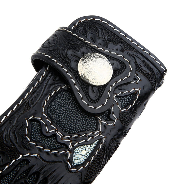 A close-up of the silver concho snap and stingray skull inlay on the gothic wallet.