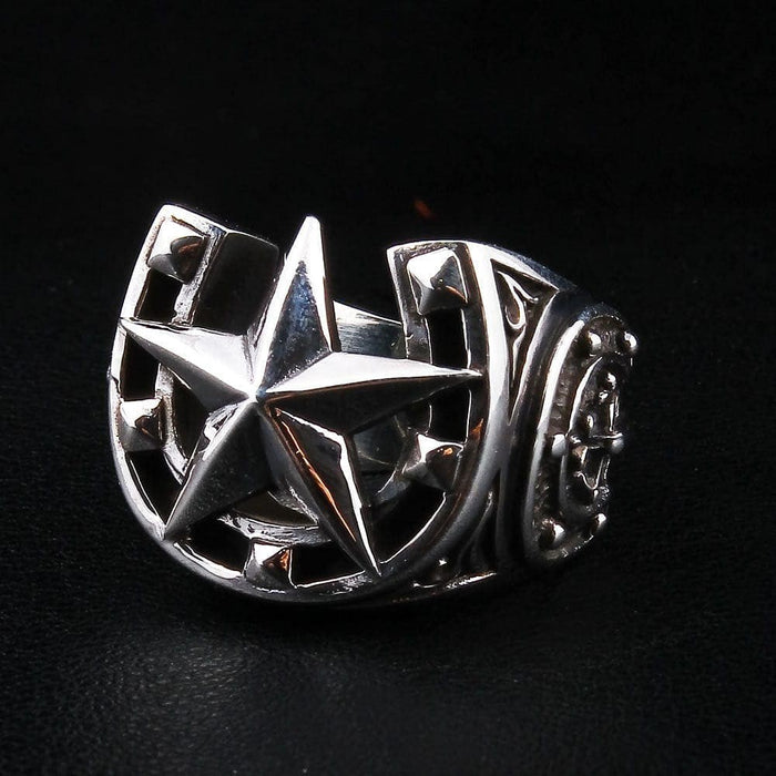 Three-quarter right angle view of sterling silver nautical star horseshoe ring with oxidized finish