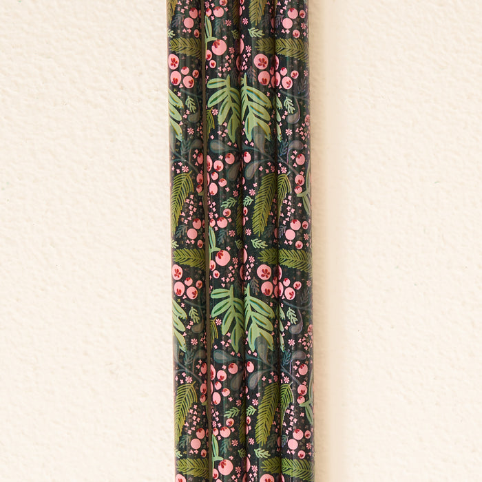 Five Jolly Sprig Green 40 oz Tumbler Straw Sets from The Darling Effect, featuring a dark floral pattern with pink berries and green leaves, are arranged vertically against an off-white textured wall, adding an eco-friendly touch to your drinkware collection.