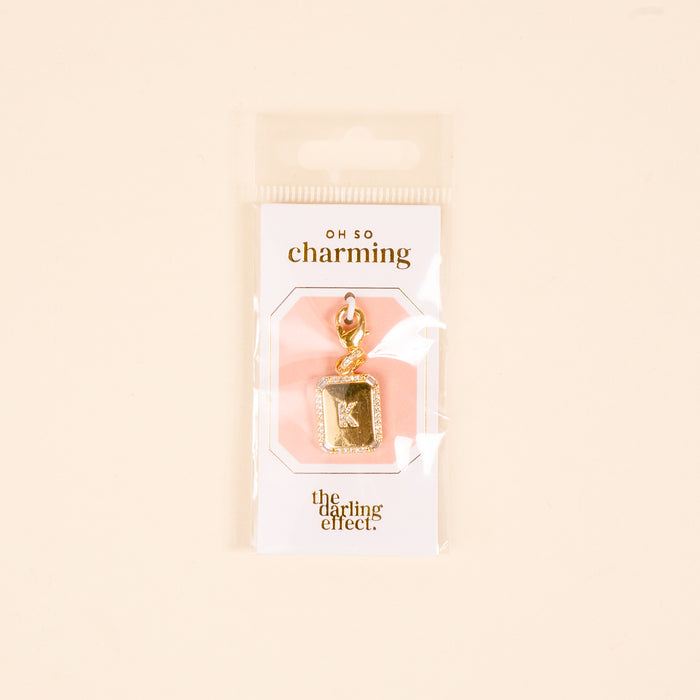 The-darling-effect K Jewelry Charm Initial Letter Gold, gold-plated and perfect for personalized jewelry, comes in rectangular OH SO charming packaging on a light beige background.