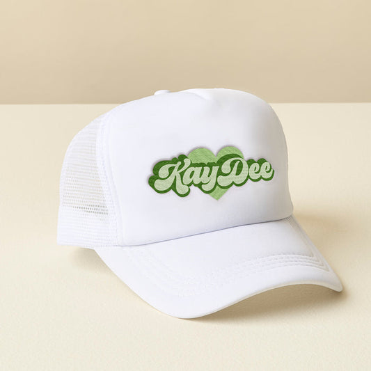 The Darling Effect's Kappa Delta White Trucker Hat features a green retro KayDee logo outlined by a heart—perfect for showing off your sisterhood style.