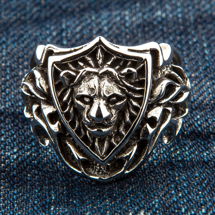 Front view emphasizing the 3D relief of the lion face and shield border on denim background.