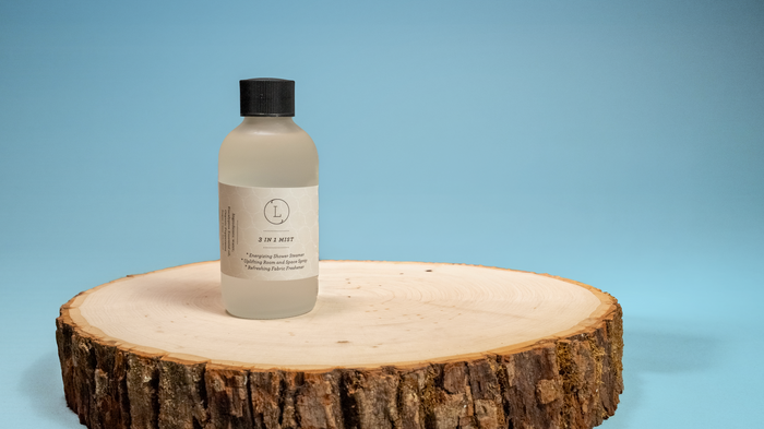 Bottle of shampoo on a wooden platform with a blue background