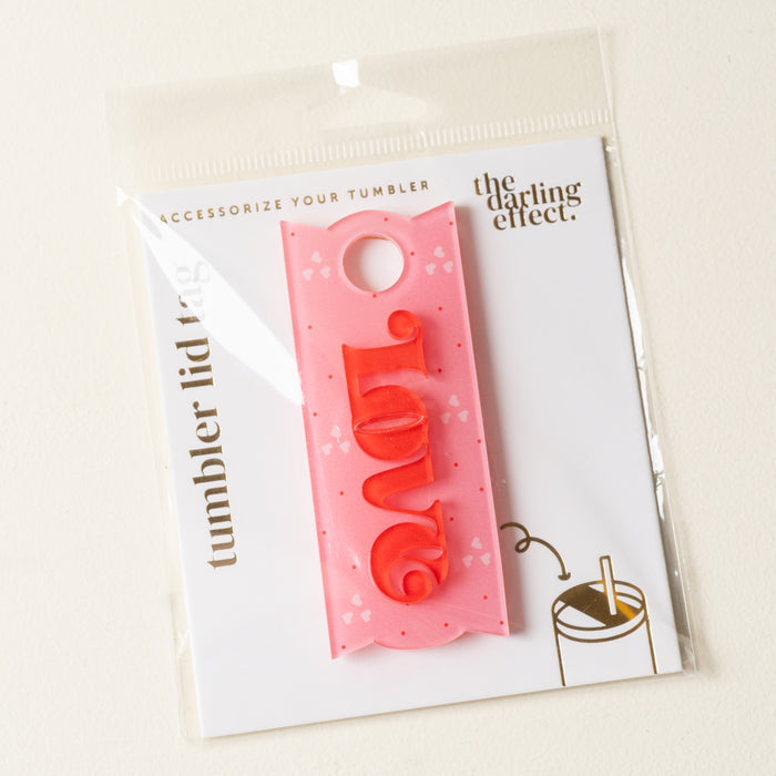 The Darling Effect Love Tumbler Lid Tag features “love” in red with heart patterns, perfect for personalizing your Stanley Quencher 2.0. Comes on a white backing card labeled The Darling Effect and Tumbler Lid Tag.