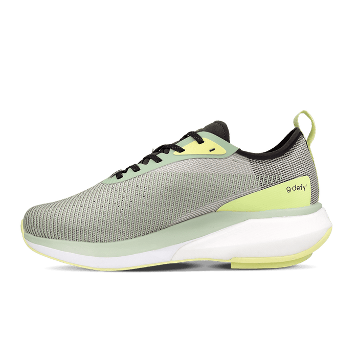 Athletic shoe with light grey-green mesh upper, white sole, and vibrant lime green accents, featuring a 'g defy' logo.