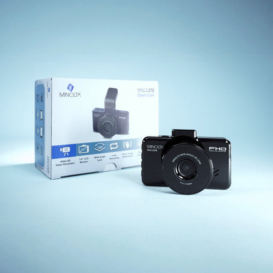Black Minolta digital camera with packaging on a light blue background