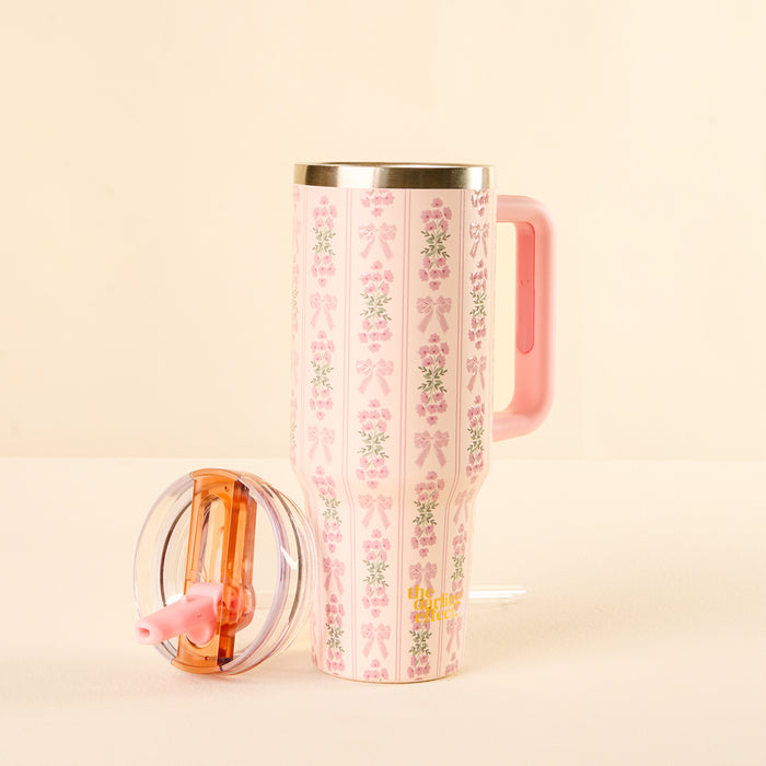 The-darling-effect Oh So Fancy Pink 40 oz Lifestyle Flip Straw Tumbler features a delicate floral and ribbon pattern, pink handle, clear leak-resistant lid, and matching pink straw.