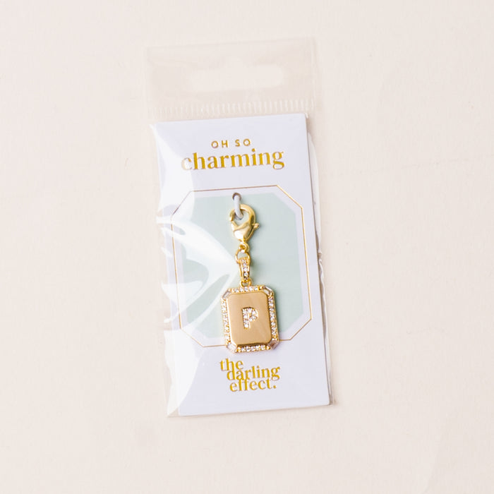 The-darling-effect P Jewelry Charm Initial Letter Gold features a gold-plated brass "P" on a card reading “OH SO charming” and “the darling effect.” This personalized charm comes in clear plastic packaging.