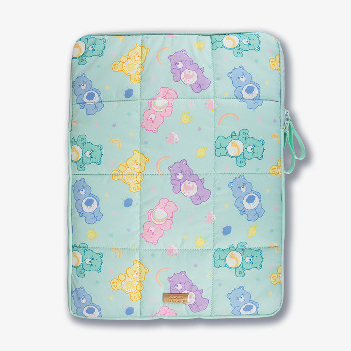 Top-front view of puffy laptop sleeve showcasing quilted pastel Care Bears print, zipper and wrist strap on a light background