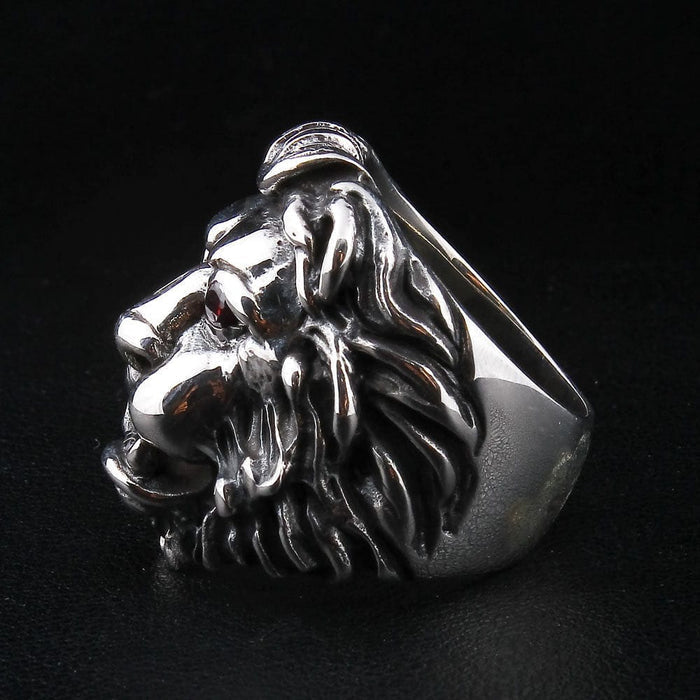 The aggressive red eyes lion ring displayed dramatically against a black background.