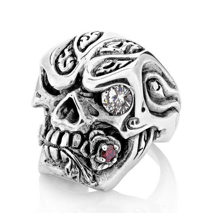 Sterling silver Rose Skull Ring featuring a clear gemstone eye, intricate forehead carvings, and a red stone rose in the jaw.
