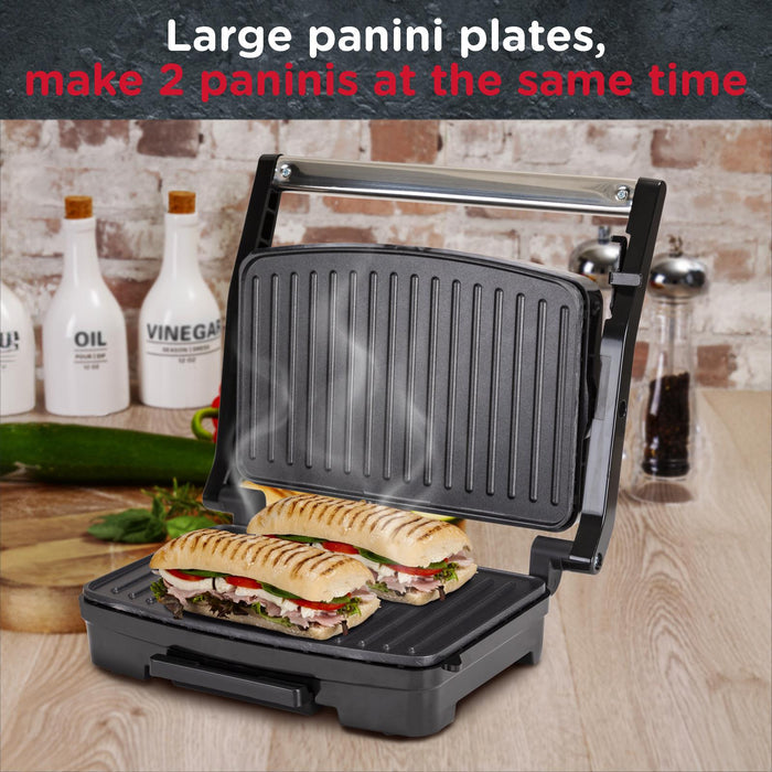Panini press with two paninis inside, surrounded by oil and vinegar bottles on a wooden surface. - Buy Now Panini Press, Sandwich Toaster & Health Grill