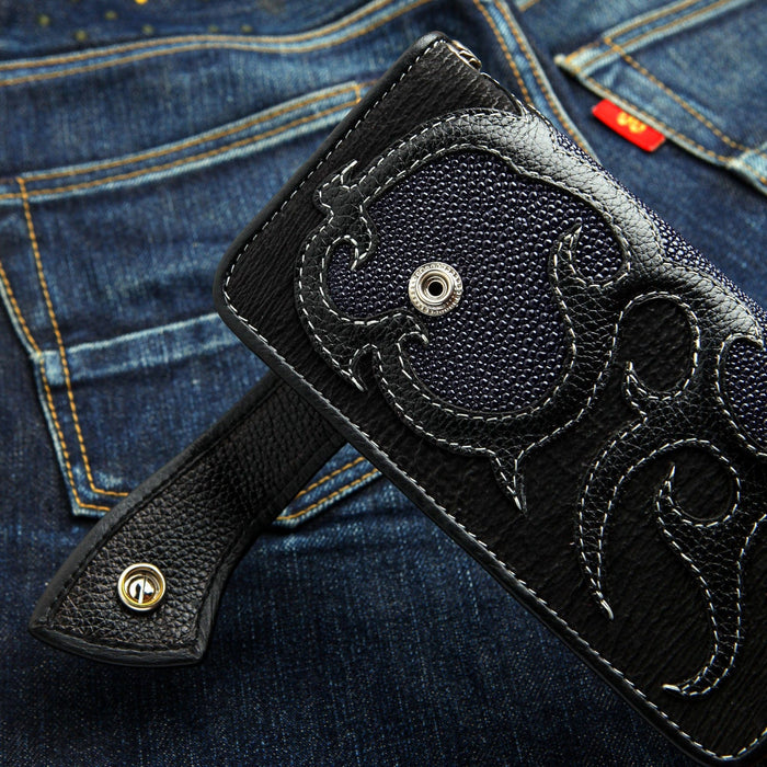 A unique navy blue stingray wallet with a hand-carved tribal flame design.