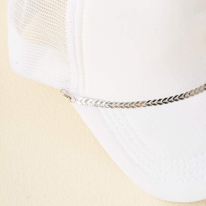 A white mesh trucker hat featuring The Darling Effect's Silver-Leaf Chain Trucker Hat Chain as a bold front-brim accessory, photographed on a light beige background.