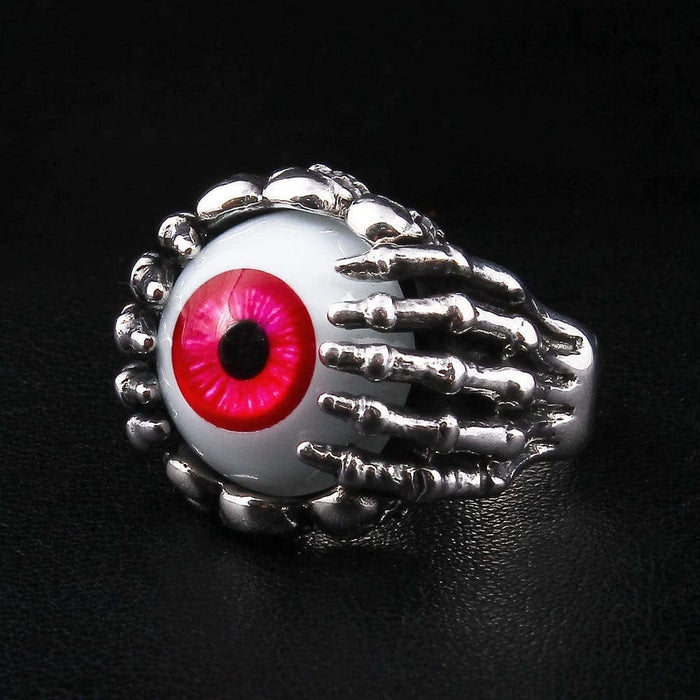 Gothic sterling silver ring featuring skeletal hand gripping red eyeball showing bone finger details