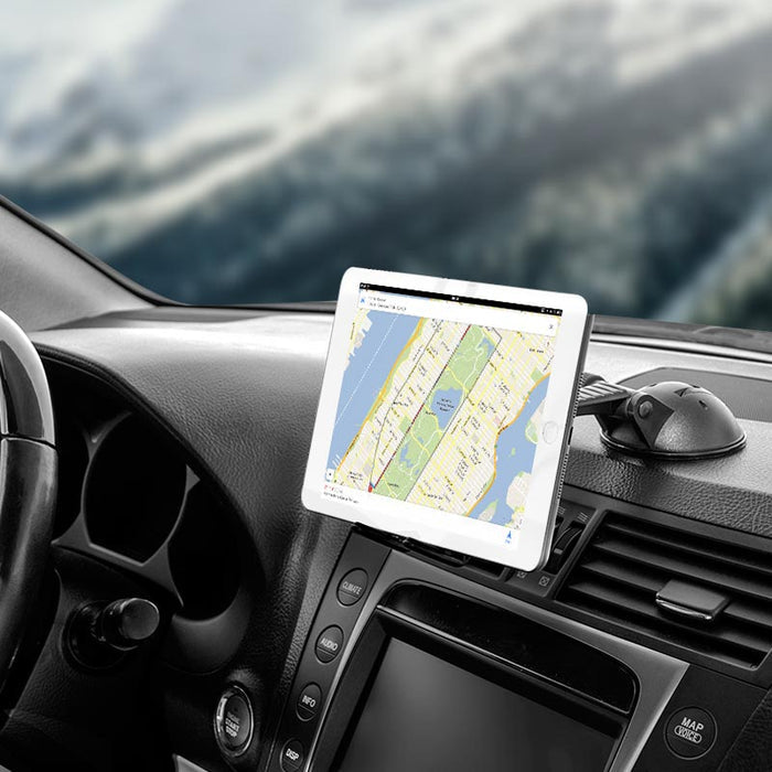 A Slim-Grip® Ultra Sticky Suction Windshield or Dash Phone Car Mount securely holds a tablet displaying a map on a car dashboard, with the steering wheel, controls, and a blurred outdoor scene visible through the windshield.