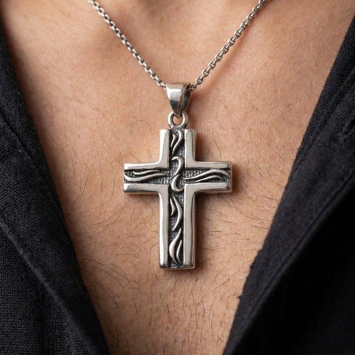 Lifestyle view showing the small .925 silver tribal cross worn on a chain around the neck to demonstrate everyday scale.
