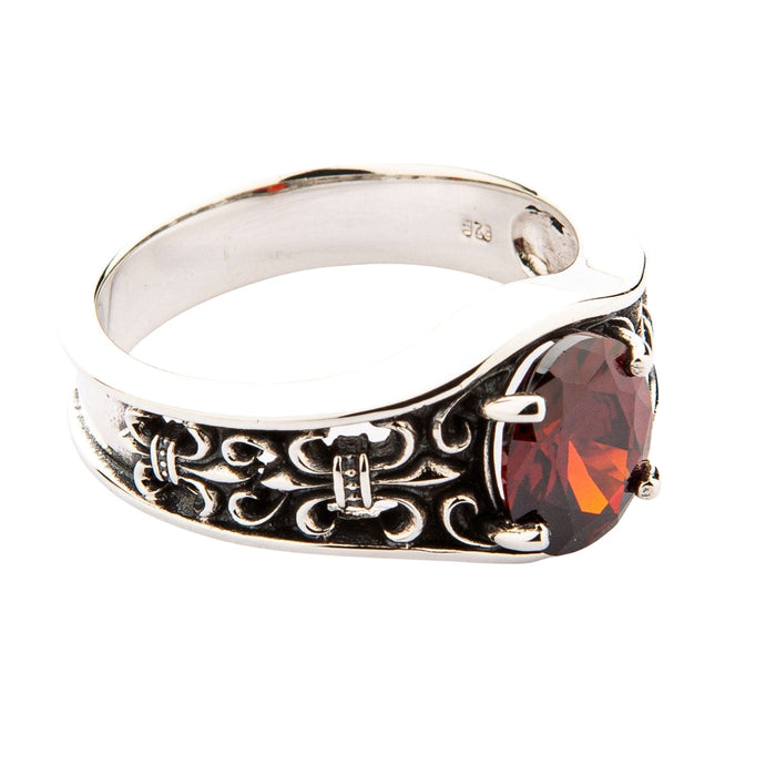 A sterling silver heraldic ring for men with an oval-cut garnet centerpiece.