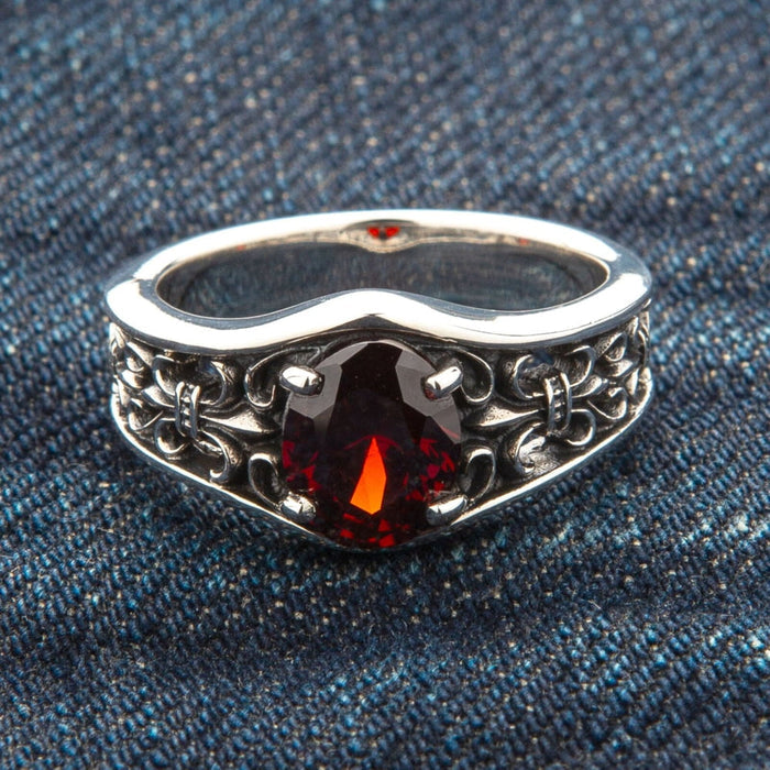 A men's January birthstone ring, featuring a genuine garnet and a sterling silver Fleur de Lis design.