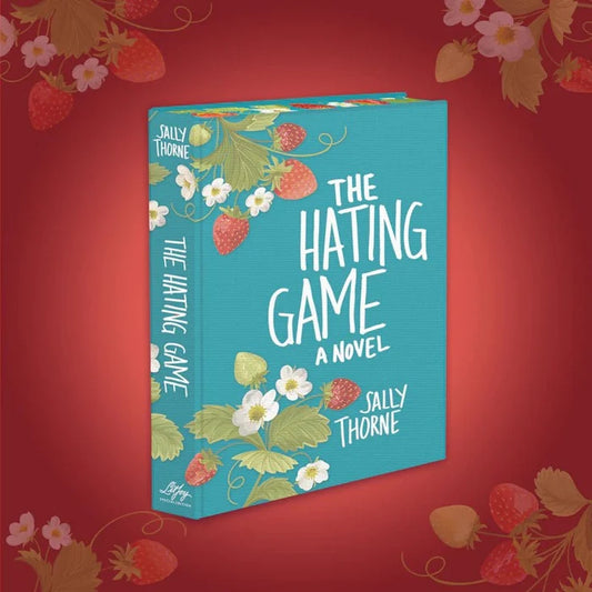 The Hating Game LitJoy Special Edition hardcover book by Sally Thorne — teal cloth-bound cover with hand-lettered title typography and botanical strawberry and white blossom illustration, angled 3D book mockup on red background, LitJoy Crate exclusive