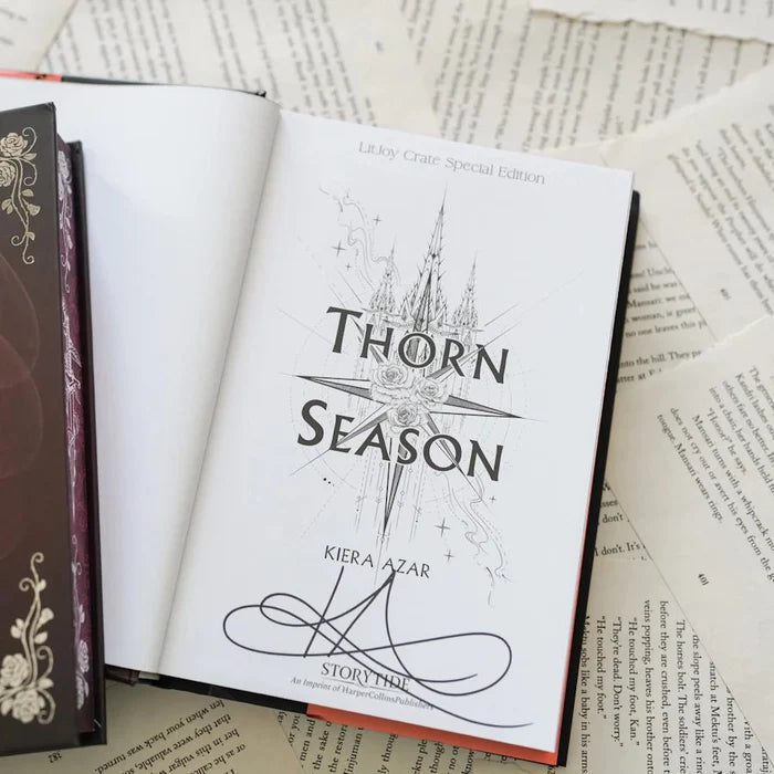 This image shows an open book titled "Thorn Season" by Kiera Azar, placed on top of several other books and papers. The book cover features a stylized castle and roses design with the title and author's name prominently displayed. The book is part of the LitJoy Crate Special Edition, as indicated by the text at the top of the cover.