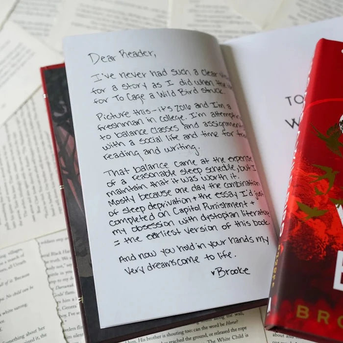 Exclusive handwritten Dear Reader author letter from Brooke Fast inside the To Cage a Wild Bird LitJoy Edition, signed with a heart, open beside the red LitJoy hardcover and scattered book pages